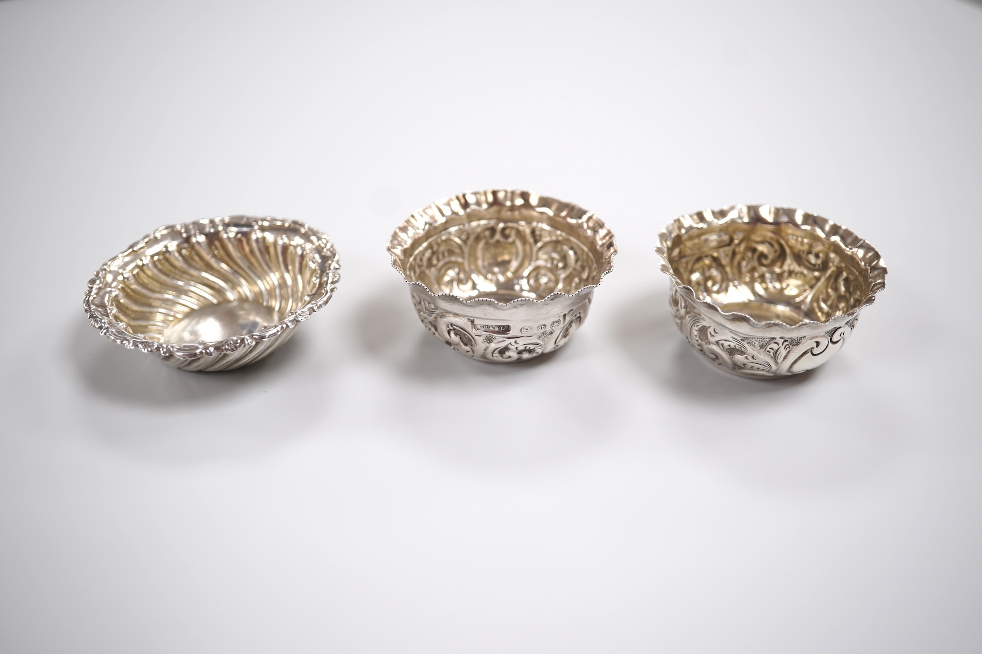 A group of small silver including a modern mounted wine coaster by M C Hersey & Son Ltd, diameter 12.6cm, a set of three George V nut dishes, one other silver nut dish, two pairs of salts including cauldron by William Hu